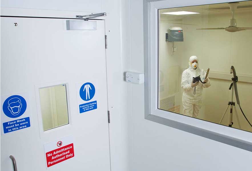 Lab researcher in full PPE evaluating MS2 bacteriophage for ASHRAE 241 evaluation of infectious aerosols