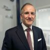 John Ryan, senior executive and strategic advisor at Airmid Healthgroup, wearing a suit and tie.