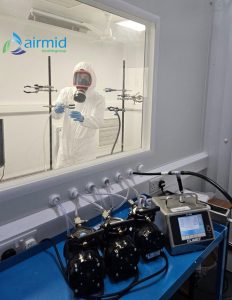 Scientist preparing bioaerosol equipment for vacuum cleaner emissions testing at Airmid Healthgroup laboratory