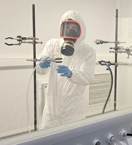 Scientist in protective suit conducting bioaerosol sampling inside Airmid Healthgroup's EN 14476:2013 testing facility