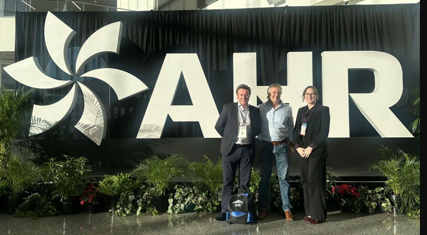 | Airmid Healthgroup John McKeon with Mark Hernandez and Kimberly Wieland at the AHR Expo 2026 discussing HVAC, aerobiology, and indoor air quality