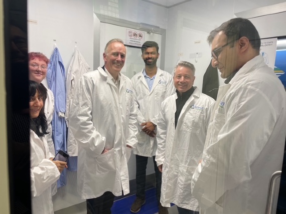 ASHRAE President Bill McQuade stands with the Airmid Healthgroup research team in the Dublin aerobiology laboratory, wearing protective lab coats while discussing infectious aerosol science and Indoor Environmental Quality testing capabilities
