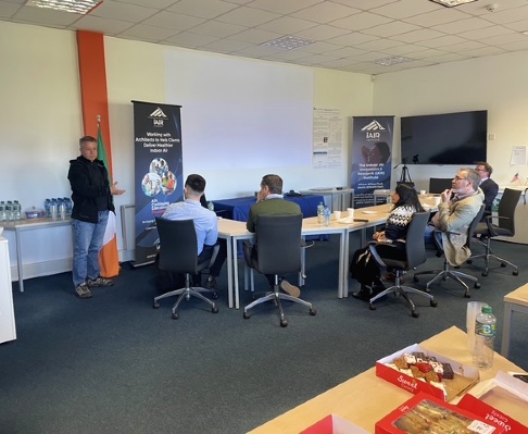 Bill McQuade leads a working session at the iAIR Institute in Dublin, with ASHRAE leadership and team members seated around a conference table, featuring iAIR banners highlighting work on healthy buildings and Indoor Environmental Quality