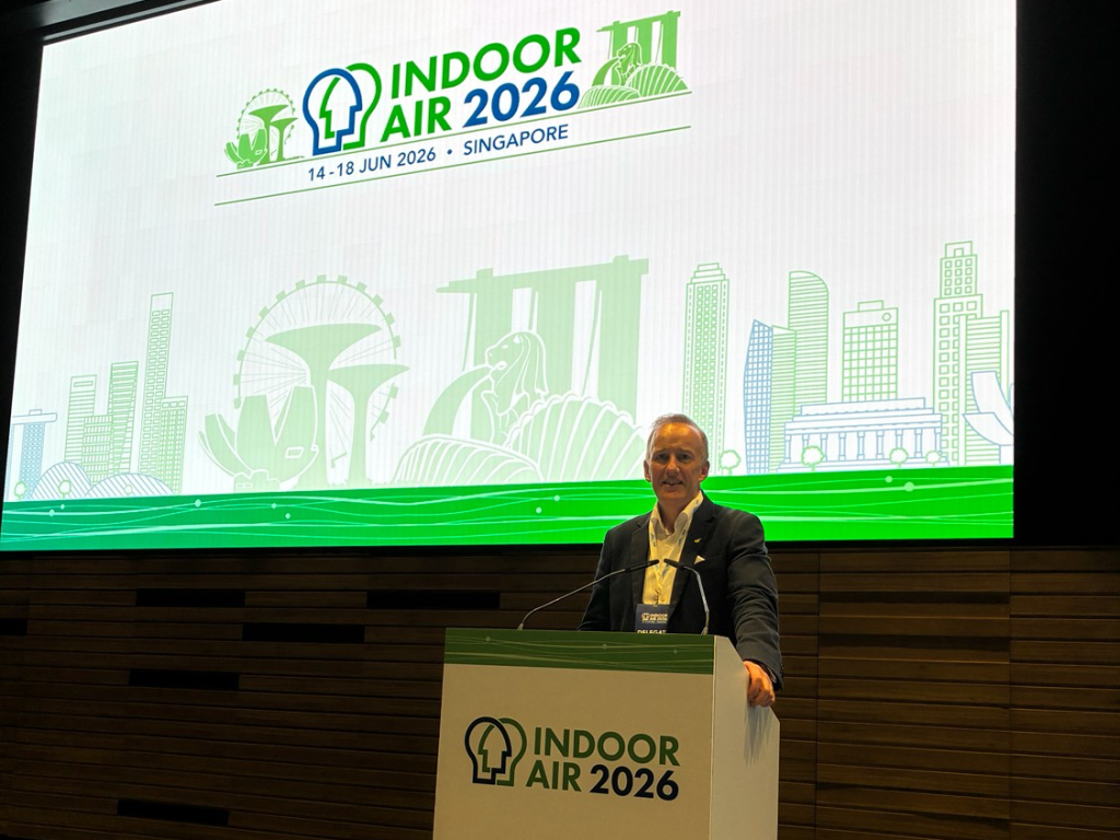 Airmid Healthgroup CEO Dr. John Ryan presenting HVAC duct cleaning testing research at the Indoor Air 2026 conference podium in Singapore